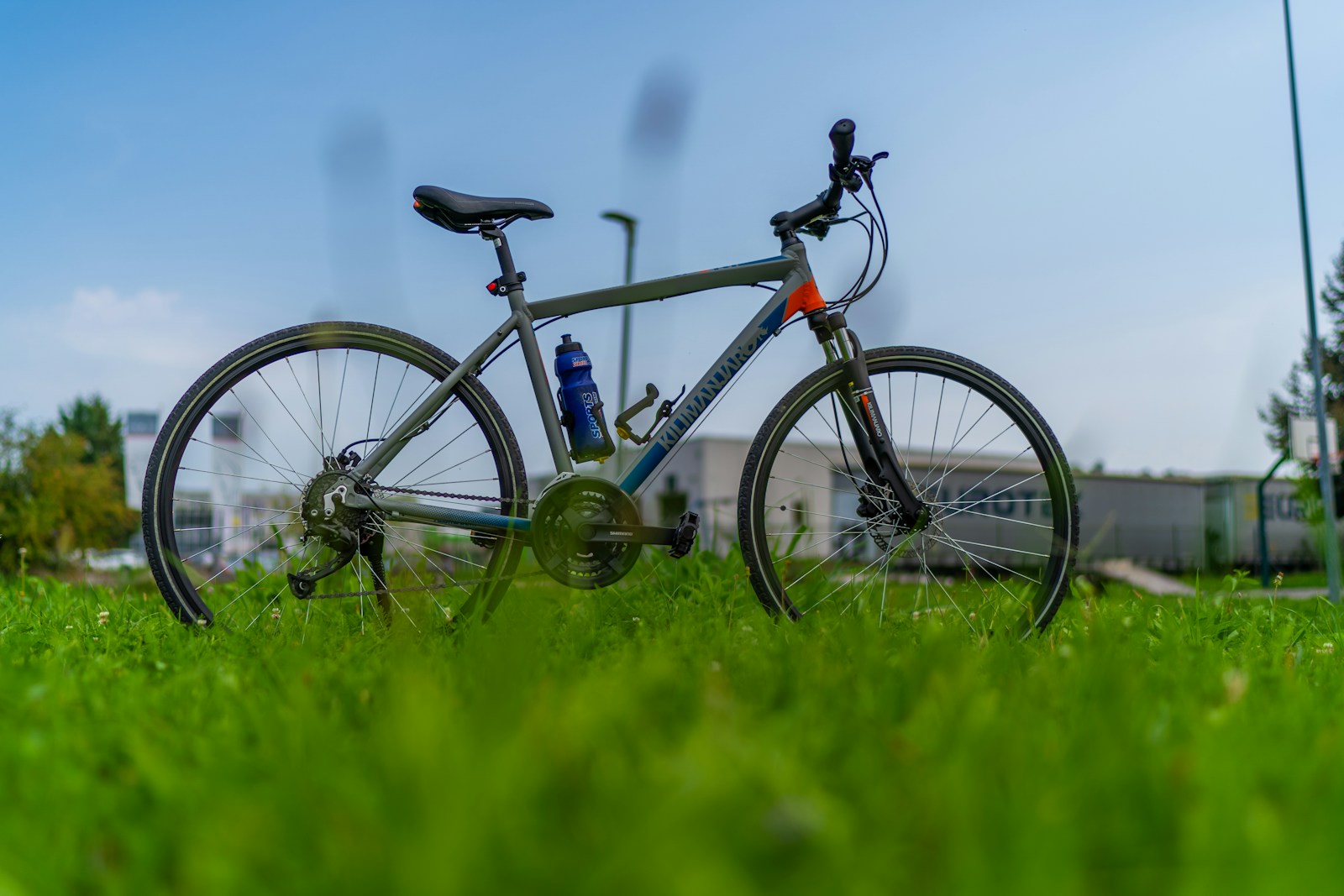 A bicycle parked in the grass near a building